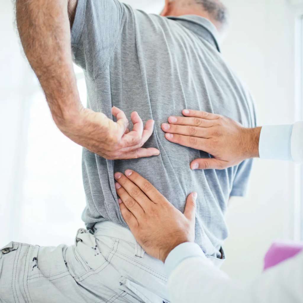 Practitioner reviewing a patient’s medical history and posture before therapy